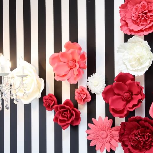 黒白ストライプの壁に赤・ピンク・白のお花が飾られているスタジオ