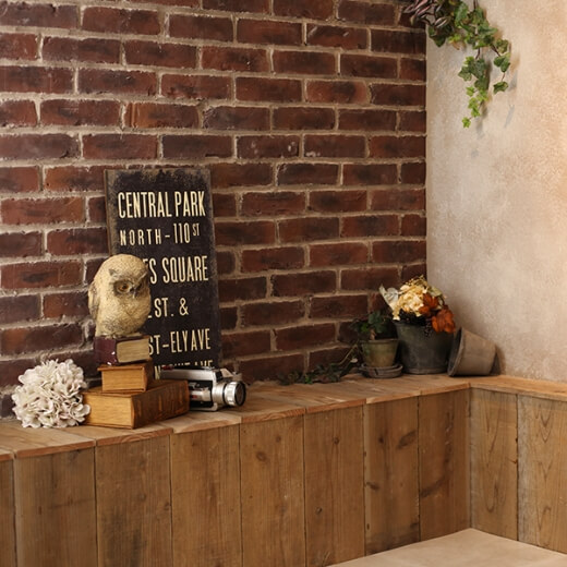 レンガの壁と木製の台の上に本や看板などの、オシャレな小物が飾られているスタジオ
